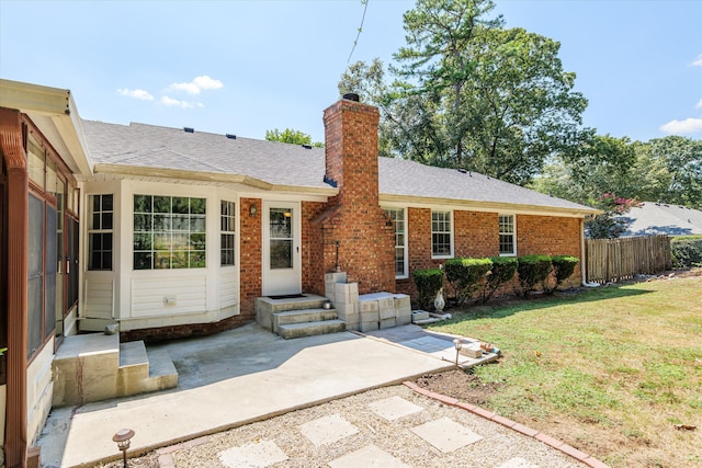 back of property with a patio and a lawn