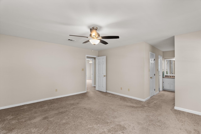 spare room with ceiling fan and light carpet