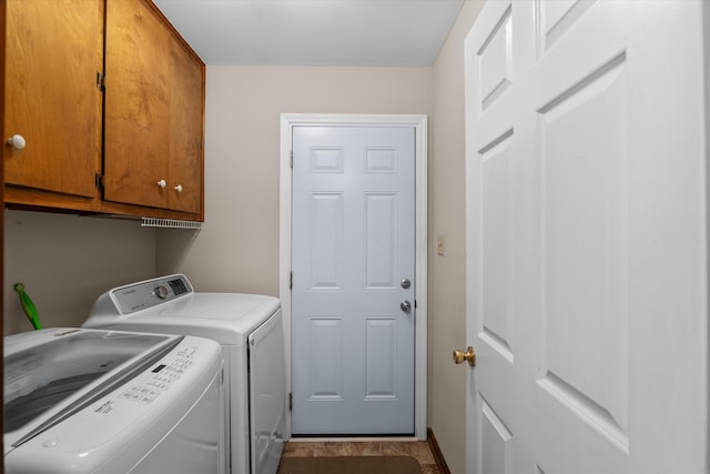 laundry room featuring washer and dryer and cabinets