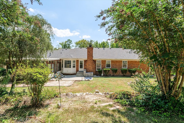 back of property featuring a sunroom, a yard, and a patio