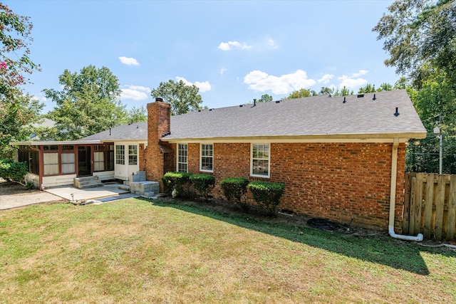 view of front of property featuring a front yard and a sunroom