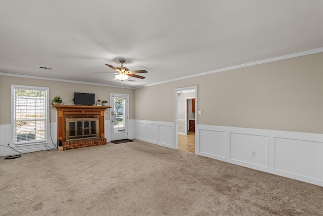 unfurnished living room featuring carpet flooring, crown molding, a fireplace, and ceiling fan