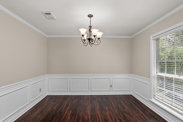 empty room with a notable chandelier, dark hardwood / wood-style floors, and ornamental molding