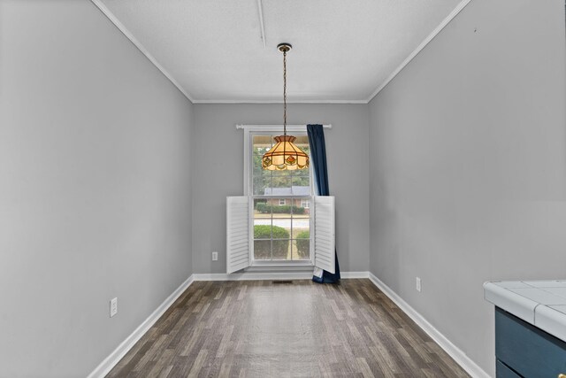 unfurnished dining area with dark hardwood / wood-style flooring and ornamental molding