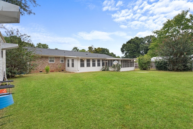 back of property featuring a lawn and a sunroom