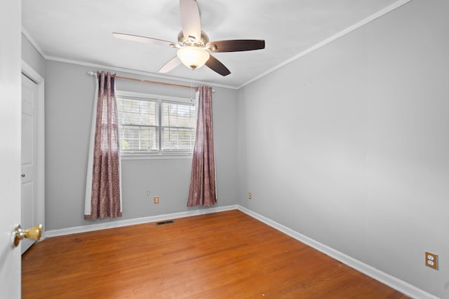 empty room with ceiling fan, wood-type flooring, and crown molding