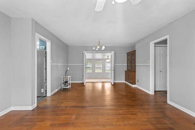 unfurnished living room with a textured ceiling, dark wood-type flooring, and ceiling fan with notable chandelier