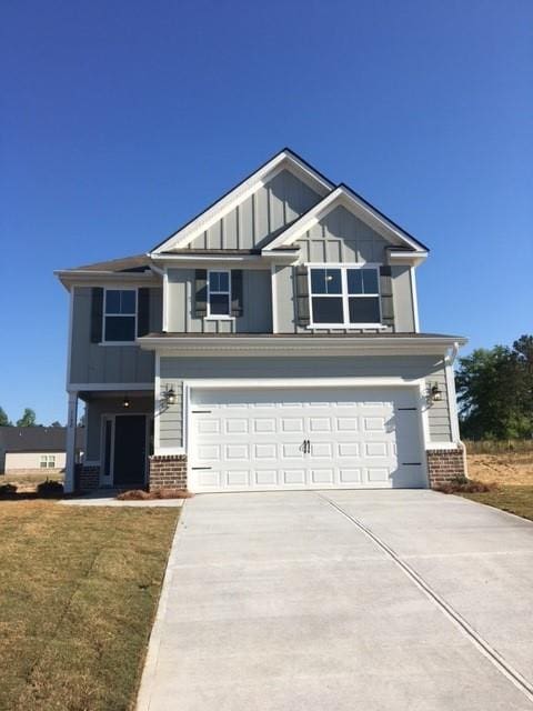 craftsman-style house with driveway, brick siding, board and batten siding, and an attached garage