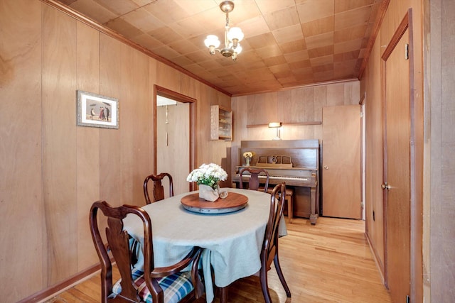 1730 Kissingbower Rd, Augusta, GA 30904 - dining space with wood walls, light wood finished floors, crown molding, and a chandelier
