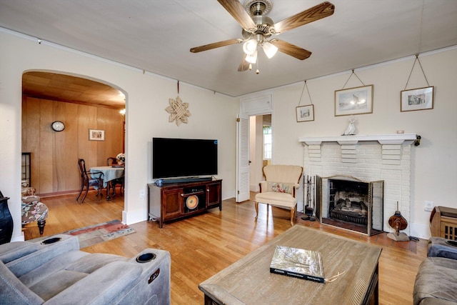 1730 Kissingbower Rd, Augusta, GA 30904 - living room featuring arched walkways, a ceiling fan, light wood-style floors, and a fireplace