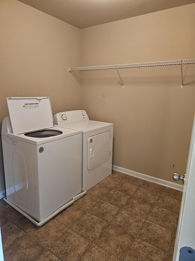 laundry room with laundry area, washer and clothes dryer, and baseboards