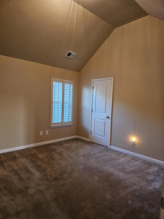 bonus room with lofted ceiling, visible vents, dark carpet, and baseboards