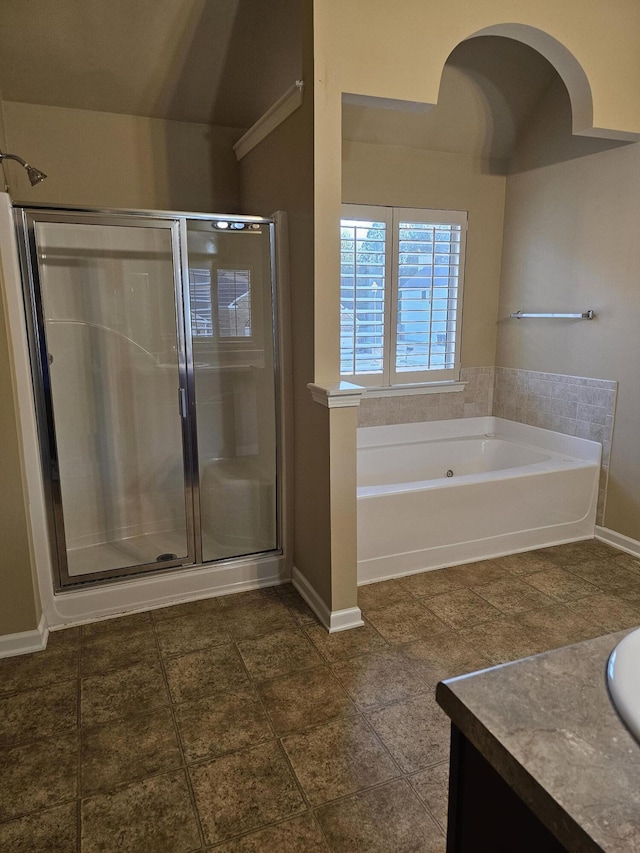 full bathroom featuring vanity, a shower stall, a bath, and baseboards