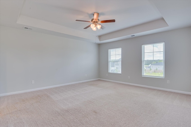 6093 Whitewater Dr, North Augusta, SC 29841 - spare room featuring a tray ceiling, light colored carpet, and a ceiling fan