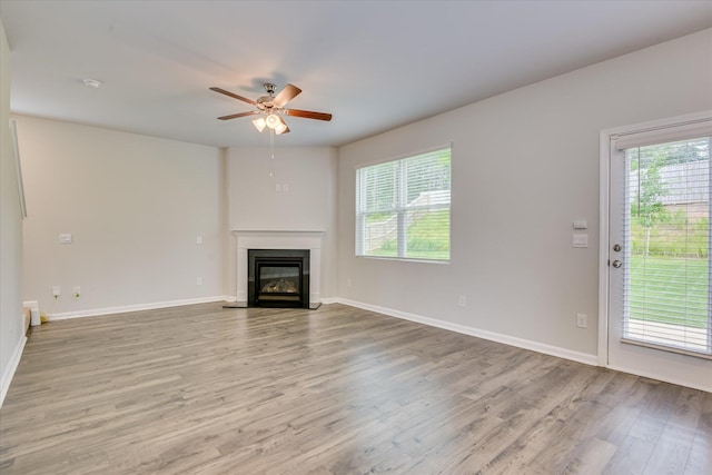 6093 Whitewater Dr, North Augusta, SC 29841 - unfurnished living room featuring plenty of natural light, a ceiling fan, light wood-style flooring, and a glass covered fireplace