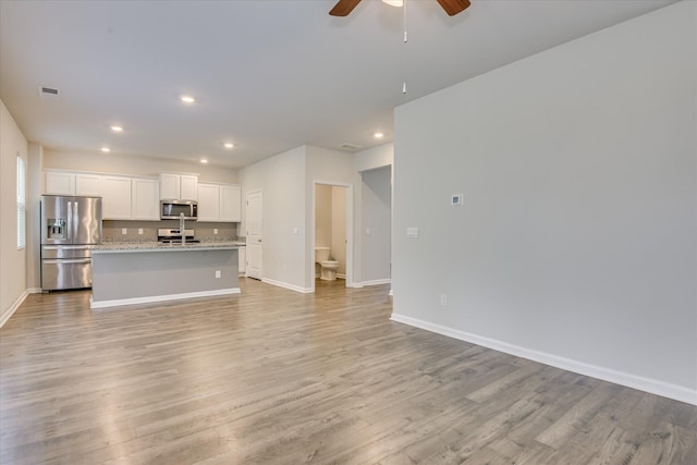 6093 Whitewater Dr, North Augusta, SC 29841 - kitchen featuring stainless steel appliances, ceiling fan, an island with sink, open floor plan, and light wood-style floors