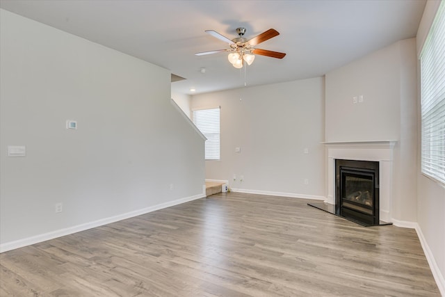 6093 Whitewater Dr, North Augusta, SC 29841 - unfurnished living room featuring a ceiling fan, plenty of natural light, wood finished floors, and a glass covered fireplace