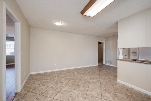 unfurnished living room with light tile patterned floors and a textured ceiling