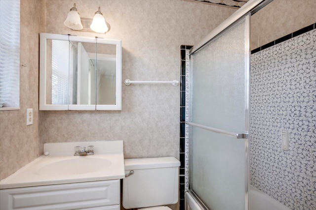 full bathroom with vanity, combined bath / shower with glass door, and toilet