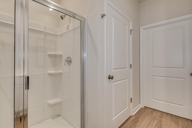 bathroom with walk in shower and hardwood / wood-style floors