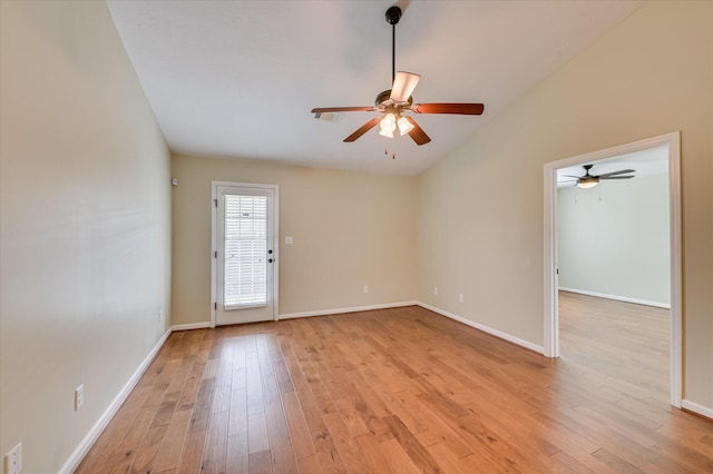 spare room featuring baseboards, light wood-style flooring, a ceiling fan, and lofted ceiling