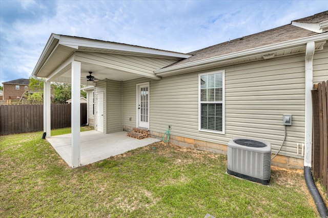 rear view of house with cooling unit, a patio, ceiling fan, and a lawn