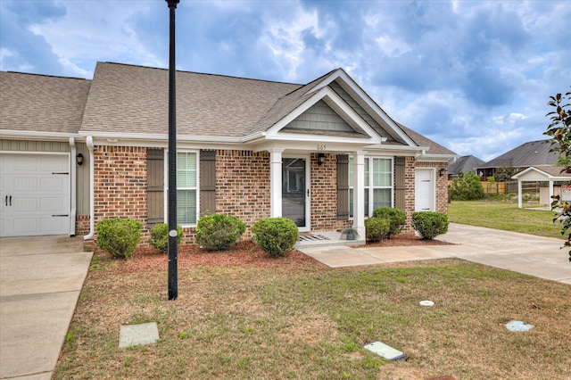 view of front of house with a front yard, a shingled roof, and brick siding