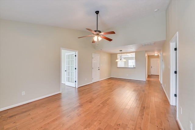 spare room featuring baseboards, light wood-type flooring, and a ceiling fan