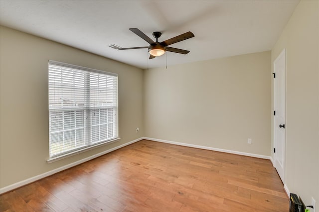 empty room featuring visible vents, ceiling fan, light wood finished floors, and baseboards
