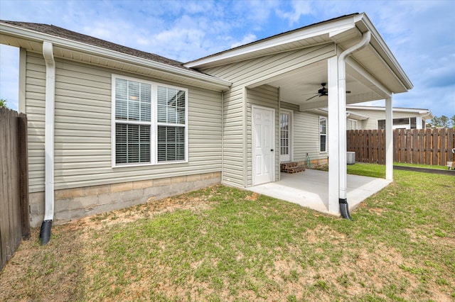 rear view of property featuring a lawn, a ceiling fan, fence, and a patio area