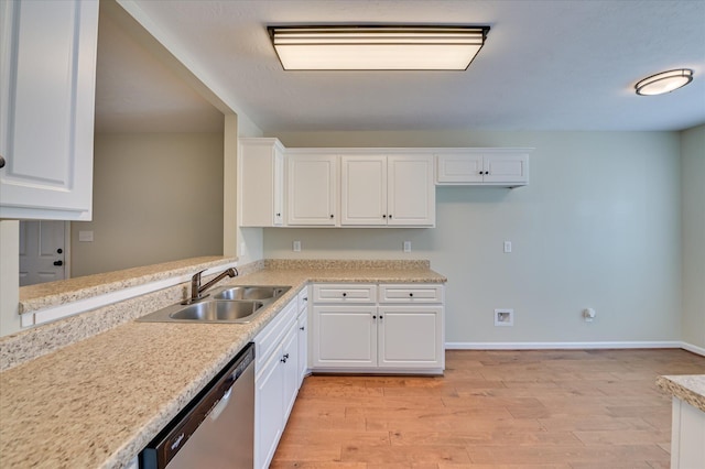 kitchen with white cabinets, dishwasher, light countertops, and a sink