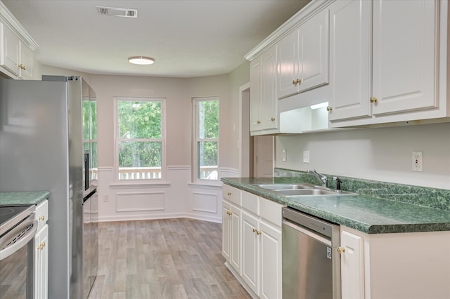 1869 Heathers Way, Augusta, GA 30906 - kitchen with stainless steel appliances, a sink, light wood-style flooring, white cabinets, and a wainscoted wall