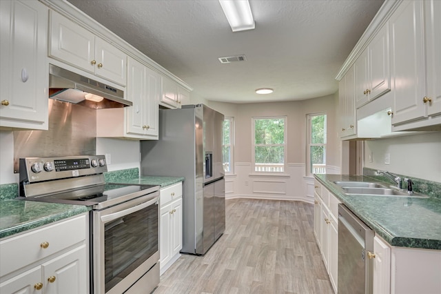 1869 Heathers Way, Augusta, GA 30906 - kitchen with appliances with stainless steel finishes, under cabinet range hood, a sink, light wood-style flooring, and white cabinetry