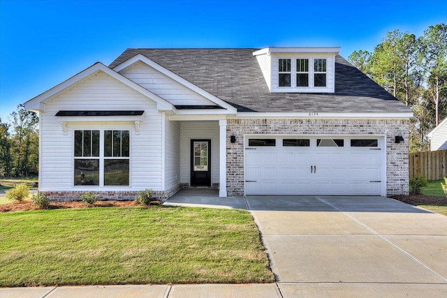 view of front of home with a front yard and a garage