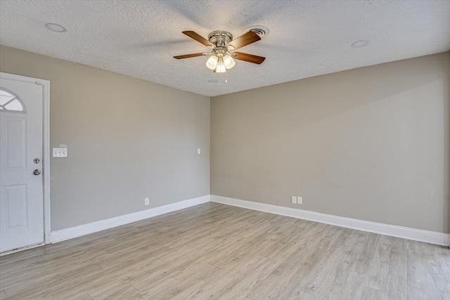 spare room with ceiling fan, light hardwood / wood-style flooring, and a textured ceiling