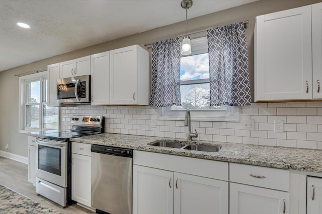 kitchen with white cabinetry, appliances with stainless steel finishes, and sink