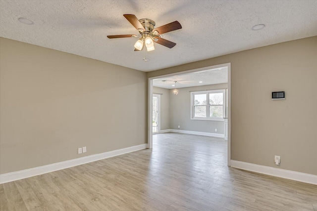 unfurnished room with ceiling fan, light hardwood / wood-style flooring, and a textured ceiling