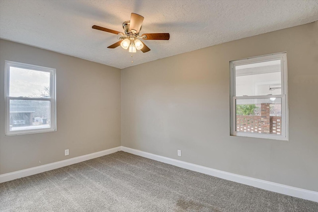 carpeted empty room with ceiling fan and a textured ceiling