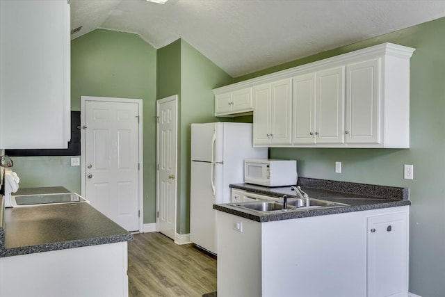 198 Eagle Lake Rd, North Augusta, SC 29841 - kitchen featuring white appliances, light wood-style floors, white cabinetry, dark countertops, and lofted ceiling