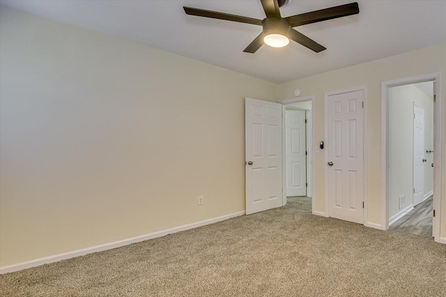 unfurnished bedroom with carpet flooring, visible vents, baseboards, and a ceiling fan