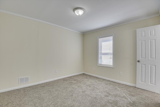 empty room with carpet, visible vents, baseboards, and ornamental molding
