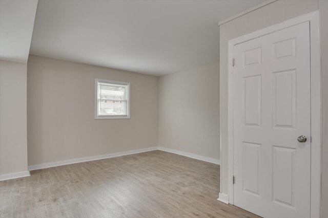 spare room featuring light wood-type flooring and baseboards