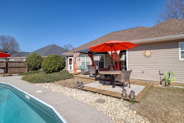 back of property featuring a patio area and a fenced in pool