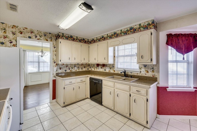 kitchen featuring light tile patterned flooring, black dishwasher, white refrigerator, and sink