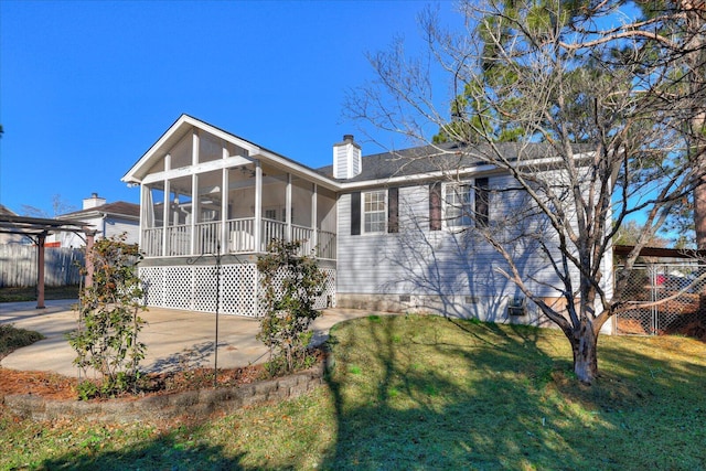 view of front of home featuring a front yard and a sunroom