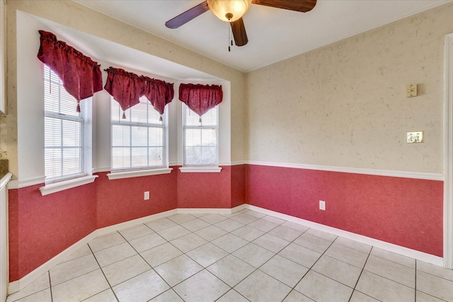 tiled spare room featuring ceiling fan