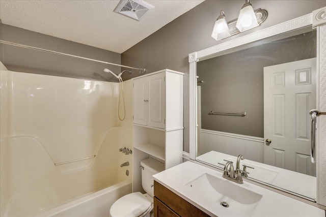 full bathroom featuring vanity, a textured ceiling, shower / bath combination, and toilet