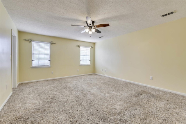 empty room with ceiling fan, carpet floors, and a textured ceiling