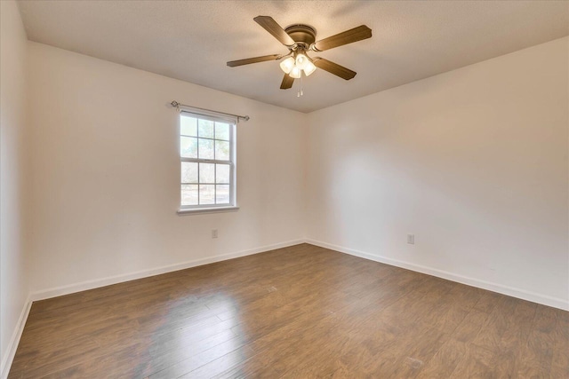 empty room with ceiling fan and dark hardwood / wood-style floors