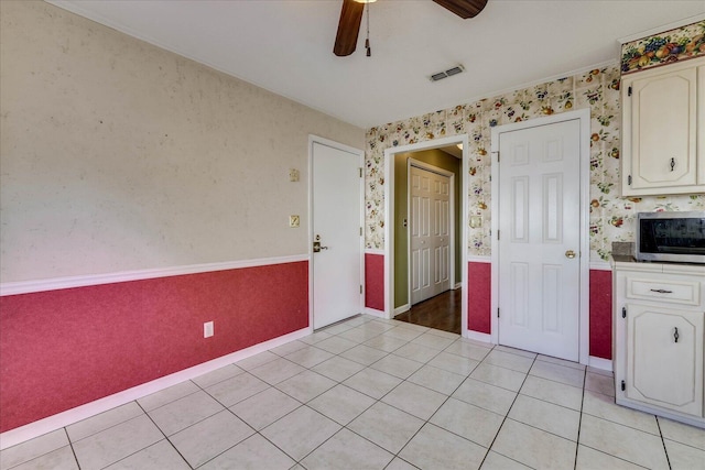 kitchen featuring light tile patterned floors, white cabinetry, and ceiling fan